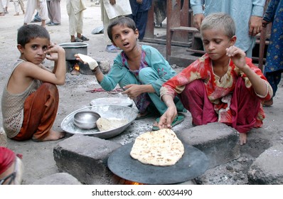 KARACHI, PAKISTAN - AUG 29: Unidentified children cook food at a flood relief camp on August 29, 2010 in Karachi.