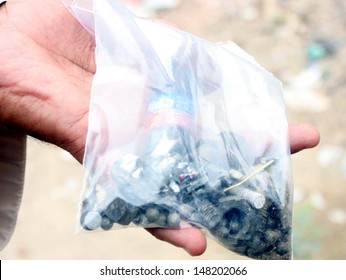KARACHI, PAKISTAN - JUL 31: Security official showing nut bolts, ball barring and iron  pieces that used in bomb to hit rangers vehicle, in Manghopir area on July 31, 2013 in Karachi.  - Shutterstock ID 148202066