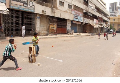 KARACHI, PAKISTAN - JUN 04: Children Are Playing Cricket On Vacant Road During The Strike Called By Muttehida Qaumi Movement In Connection Of Mourn Day On June 04, 2015 In Karachi.