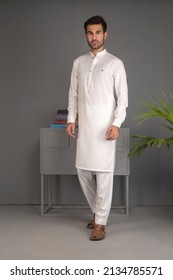 Karachi, Pakistan - March 02, 2022: Pakistani man in traditional wear  kurta pyjama cloths. Male fashion model in sherwani, posing in studio, wedding Fashion concept