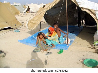 KARACHI, PAKISTAN - OCT 10: Flood affected woman picks lice of her child at make shift tent house at a flood affectees relief camp on October 10, 2010 in Karachi, Pakistan.