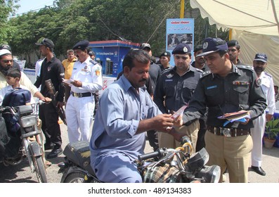 KARACHI, PAKISTAN - SEP 26: DIG Traffic Police, Dr. Ameer Sheikh Distributing Pamphlets About Awareness Of Car Safety Belts Bikers Helmets, At Hotel Metropole Road On September 26, 2016 In Karachi.