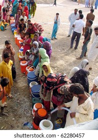 KARACHI, PAKISTAN, SEPT 30: Flood affected women and children fill their drinking water coolers at drinking water tank at flood affectees relief camp established at Hawks bay area on September 30, 2010 in Karachi, Pakistan