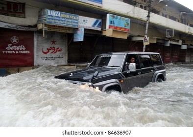 KARACHI, PAKISTAN - SEPTEMBER 13: A vehicle passes through a flooded road due to heavy downpour of Monsoon Season in Karachi on Tuesday, September 13, 2011.