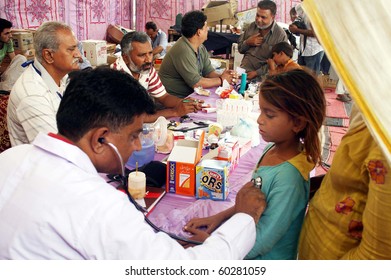 KARACHI, PAKISTAN-AUG 31: A doctor examines patients at flood relief camp established at Razzaqabad area in Karachi on Tuesday, August 31, 2010.  (Rizwan Ali/PPI Images).