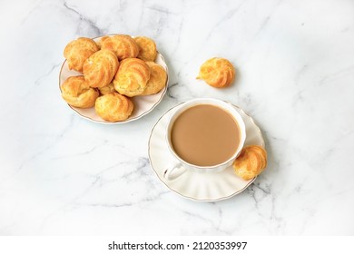 Karak Chai Or Masala Tea And Homemade Profiteroles Stuffed With Whipped Cream. On Marble Light Background. Top View.