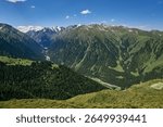Karakol Gorge, Summer natural landscape. Mountain range, dense coniferous forest and snow capped peaks. Travel destination in Kyrgyzstan, Kirgiziya Mountains. Scenery, hight point of view