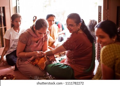 Karamsad, India - 6 February 2011: A unnamed Indian henna artist decorates the arm of the mother of the bride at a traditional Hindu pre-wedding event called the Mehndi Party. - Shutterstock ID 1111782272