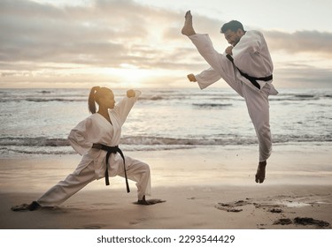 Karate all day. Shot of two young martial artists practicing karate on the beach. - Powered by Shutterstock