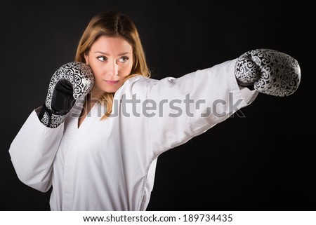 karate girl with black belt give a punch. champion of the world, portrait on black background studio shot.