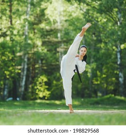 Karate Girl Makes High Kick On Forest Location