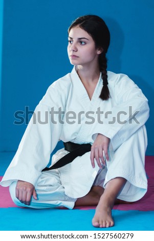 Karate girl sitting and posing in a karate gear