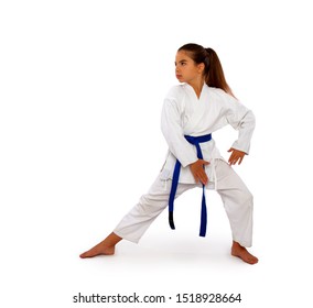 a karate girl in a white kimono and a blue belt performs an exercise from kata in training