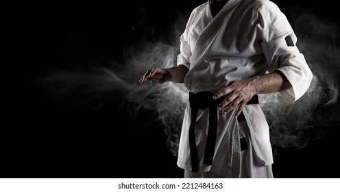 Karate master in white kimono with black belt. Sports banner on dark background