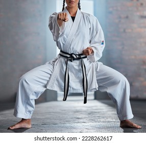 Karate, sports and fitness with a woman fighter or athlete training in a gym while wearing her gi uniform. Health, sport and workout with a female martial artist exercising in a dojo or health club - Powered by Shutterstock