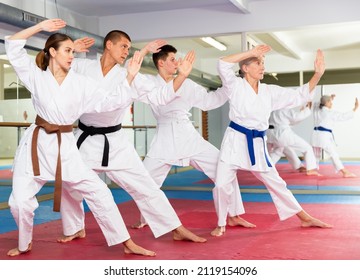 Karate Or Taekwondo Training - Athletes In Kimono Stand In A Fighting Stance