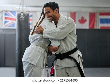 . Karate trainer giving hug to female student for motivation, coach embracing for support and celebration after winning competition. Teammates and friends training and learning martial arts at a gym - Powered by Shutterstock