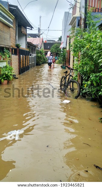 Karawang, Indonesia - February 21, 2021 : flooded\
houses, as a result of heavy rainfall. the impact of tropical\
cyclones on the pacific\
ocean