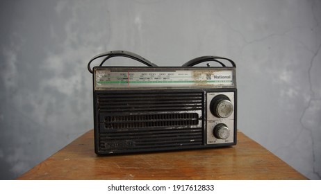 Karawang, West Java - Indonesia - February 2021: Old radio with national brand on top of wood with gray background.