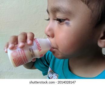 Karimun, Indonesia 26 July 2021 - A Child Is Drinking Probioic Milk Made From Fermented Skim Milk And Sugar With The Bacterium Lactobacillus Casei