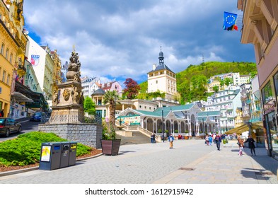 Karlovy Vary, Czech Republic, May 10, 2019: The Market Colonnade Trzni kolonada wooden colonnade with hot springs and Holy Trinity Column in town Carlsbad historical city centre, West Bohemia