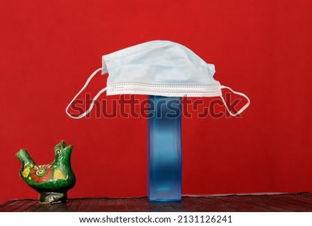 Karlshamn, Sweden. February 24, 2022. Rumanian ocarina crying for a face mask on a vase. Rumanian craft, red background.
