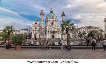Karlskirche on the Karlsplatz square hyperlapse in Vienna, Austria. People walking and sitting at fountain. It is a catholic church, also called Rektoratskirche, with a typical baroque architecture.