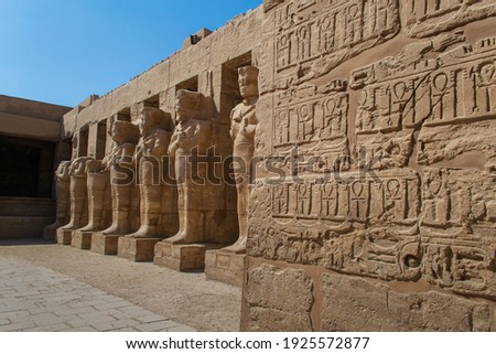 KARNAK TEMPLE - Massive columns inside beautiful Egyptian landmark with hieroglyphics, and ancient symbols. Famous landmark in the world near the Nile River and Luxor, Egypt