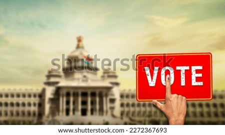 Karnataka election vote card with voters hand showing marked finger  Vidhan Soudha in background Karnataka election 2023 April