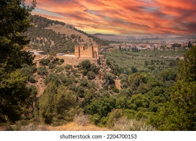 The Kasbah castle from the Middle Atlas and the Tadla plain of Morocco protecting and overlooking the Moroccan city of Beni Mellal-Jenifra under an orange sky. Concept Morocco, castle, city, landscape - Shutterstock ID 2204700153