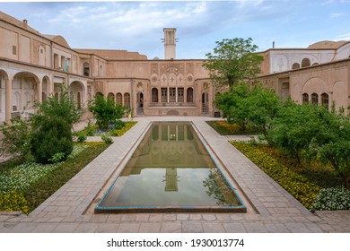 Kashan, Iran - 04.19.2019: Courtyard of richly decorated Borujerdi House, famous historical home from Qajar era. Pool, wind towers, small persian garden.
