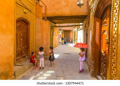 KASHGAR, CHINA - JUNE 2017: Old Town Common Uyghur Architecture Apartment Buildings Street With Playing Little Children