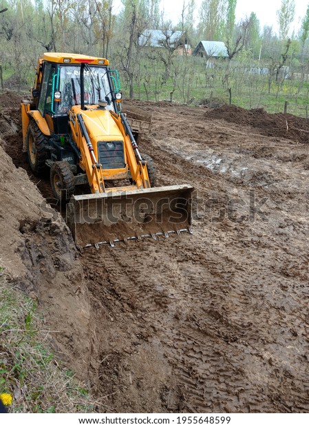 Kashmir india , 14 April 2021 , JCB is on the\
job for earth leveling