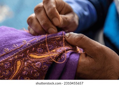 Kashmiri artist doing handmade embroidery with the help of thread needle at his shop dal lake singer Kashmir 2021