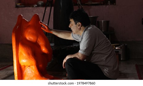 A Kashmiri Pandit Man Decorating An Idol With Vermilion (sindoor) For The Occasion Of Ganesh Chaturdashi In Ganesa Temple, Ganpatyar, Kashmir On May 23, 2021