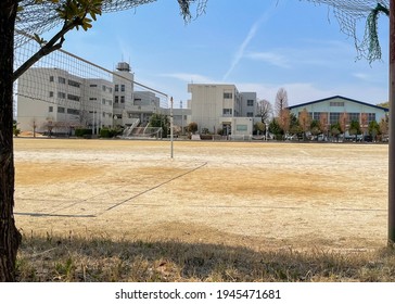 Kasukabe City, Saitama, Japan. March 27,  2021. The Deserted Playing Field Of Kasukabe City Onuma Public Junior High School With The Main School Buildings And Gym In The Background On A Sunny Day. 