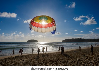 Kata Beach, Phuket, Thailand - July 15, 2016: Silhouette of  tourists are preparing parasailing at kata beach in Phuket.