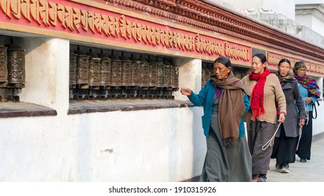Kathmandu, Nepal - 02.16.2015: Women at the mani wall at Swayambhunath or Monkey temple, rolling prayer wheels