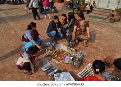 KATHMANDU, NEPAL - 13 MAY 2015: People lighting prayer candles in the streets of Kathmandu. Candles are a traditional part of Buddhist ritual observances & are placed as a show of respect. Editorial.