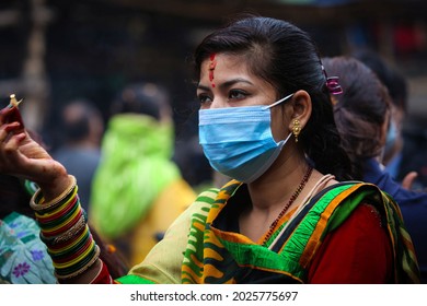 Kathmandu, Nepal - August 16, 2021: A Nepali Woman With Face Mask Offers Prayers On Shrawan Somvar (Mondays Of Holy Month) At A Shiva Temple Amid COVID-19 Outbreak.