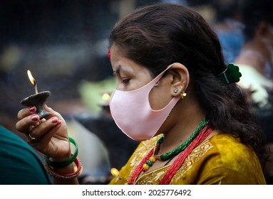 Kathmandu, Nepal - August 16, 2021: A Nepali Woman With Face Mask Offers Prayers On Shrawan Somvar (Mondays Of Holy Month) At A Shiva Temple Amid COVID-19 Outbreak.