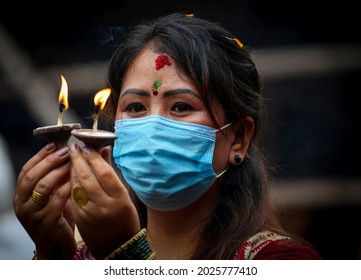 Kathmandu, Nepal - August 16, 2021: A Nepali Woman With Face Mask Offers Prayers On Shrawan Somvar (Mondays Of Holy Month) At A Shiva Temple Amid COVID-19 Outbreak.