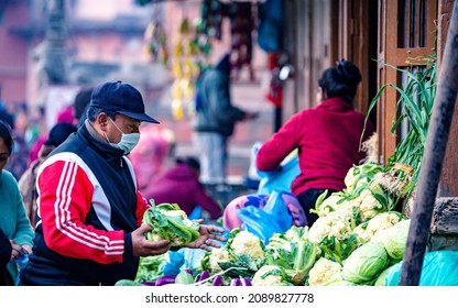 KATHMANDU, NEPAL - December 11, 2021: People Wearing Mask And Selling Vegetables On Street Market, Daily Stuggle Life Of Street Vendor During Covid Pandemic At Kathmandu.
