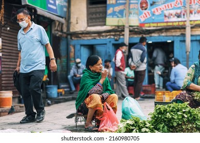 Kathmandu, Nepal - May 2022 : An Old Greengrocer Smoking At A Local Market 