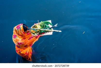 KATHMANDU, NEPAL - NOVEMBER 10, 2021: An ancient Hindu festival, dedicated to Lord Surya and Chhathi, A devotee offers prayers to the setting sun during the “Chhath” festival at River in Kathmandu.