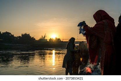 KATHMANDU, NEPAL - NOVEMBER 11, 2021: An ancient Hindu festival, dedicated to Lord Surya and Chhathi, A devotee prepairing goods during the “Chhath” festival at River in Kathmandu.
