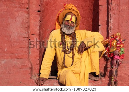 Kathmandu Sadhu men holy person in hinduism with traditional painted face at Pashupatinath Temple of Kathmandu - Non English word in image is prayer words