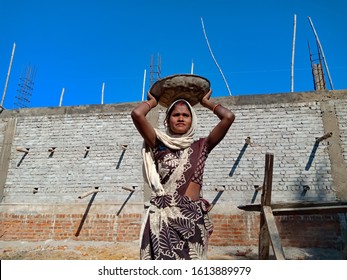 Katni, INDIA - January 2020: Indian Woman Labour Holded Raw Material Container On Head During Work At Construction Site 