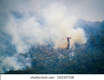 Katoomba, New South Wales / Australia - December 1st 2019: NSW Rural Fire Service drop water from a helicopter onto Ruined Castle Bush Fire in the Blue Mountains.