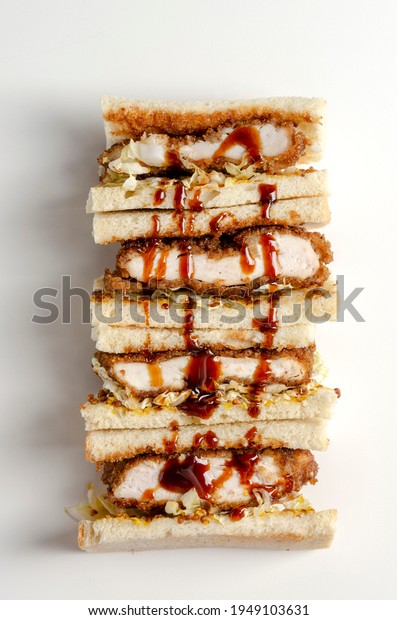 Katsu sandos japanese\
sandwich with chicken or pork chop, cabbage and tonkatsu sauce\
isolated on white.